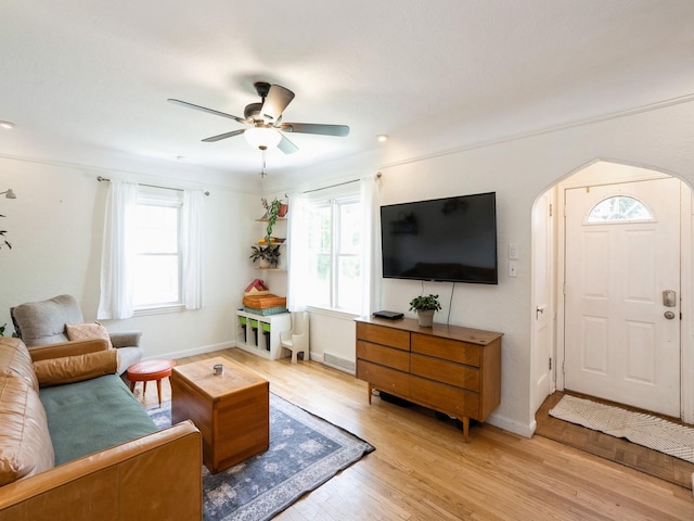 1655 NW Dr, Des Moines, IA 50310 - living room with arched walkways, healthy amount of natural light, light wood finished floors, and ceiling fan
