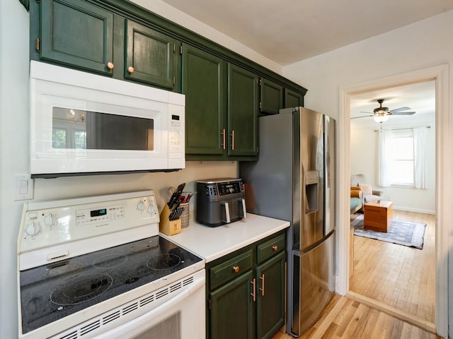 1655 NW Dr, Des Moines, IA 50310 - kitchen featuring white appliances, green cabinets, light wood-style floors, and light countertops