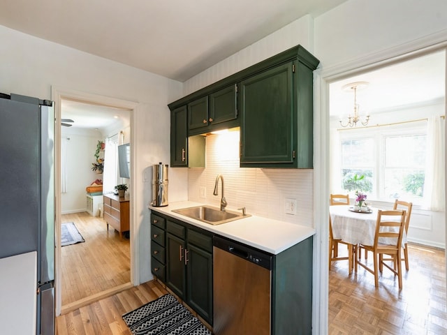 1655 NW Dr, Des Moines, IA 50310 - kitchen featuring appliances with stainless steel finishes, green cabinetry, light countertops, decorative backsplash, and a chandelier