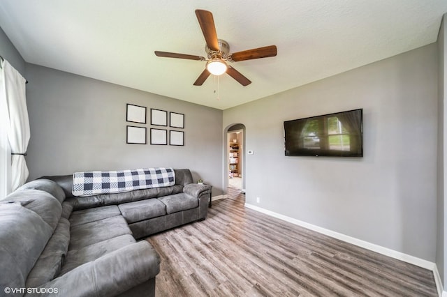 3411 61st St, Des Moines, IA 50322 - living room featuring arched walkways, wood finished floors, and a ceiling fan