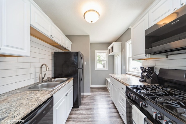 3411 61st St, Des Moines, IA 50322 - kitchen featuring black appliances, white cabinetry, decorative backsplash, and wood finished floors