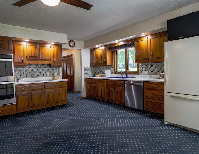 1108 Hillcrest Ct, Chariton, IA 50049 - kitchen with appliances with stainless steel finishes, dark carpet, light countertops, ceiling fan, and a textured ceiling