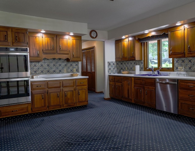 1108 Hillcrest Ct, Chariton, IA 50049 - kitchen featuring stainless steel appliances, light countertops, dark carpet, and decorative backsplash