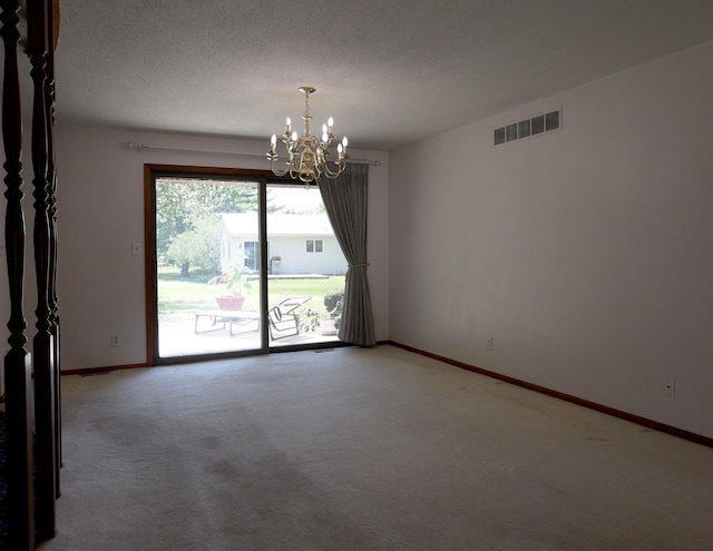1108 Hillcrest Ct, Chariton, IA 50049 - spare room featuring a chandelier, light carpet, and a textured ceiling