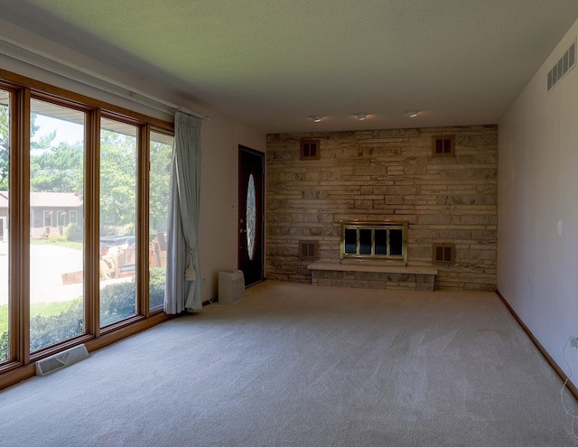 1108 Hillcrest Ct, Chariton, IA 50049 - unfurnished living room with carpet floors, healthy amount of natural light, and a fireplace