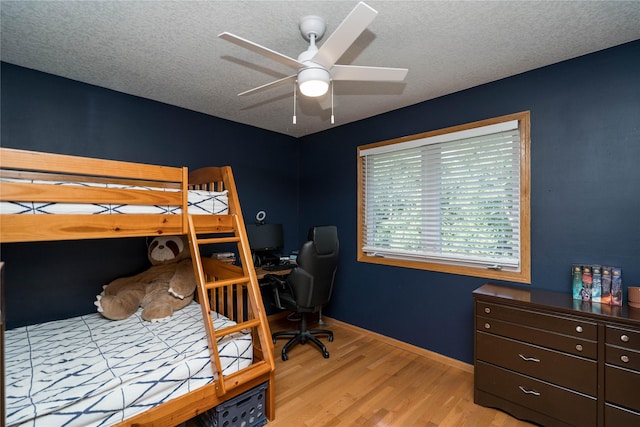 3605 80th St, Urbandale, IA 50322 - bedroom with light wood finished floors, an office area, a textured ceiling, and ceiling fan