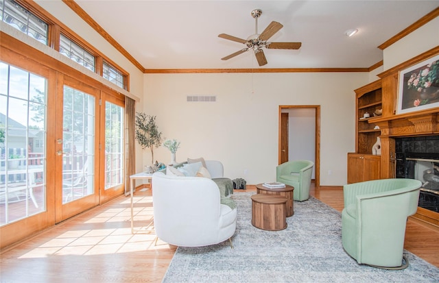 5925 Ep True Pkwy Unit 36, West Des Moines, IA 50266 - living room with a glass covered fireplace, ornamental molding, french doors, light wood-style floors, and a ceiling fan