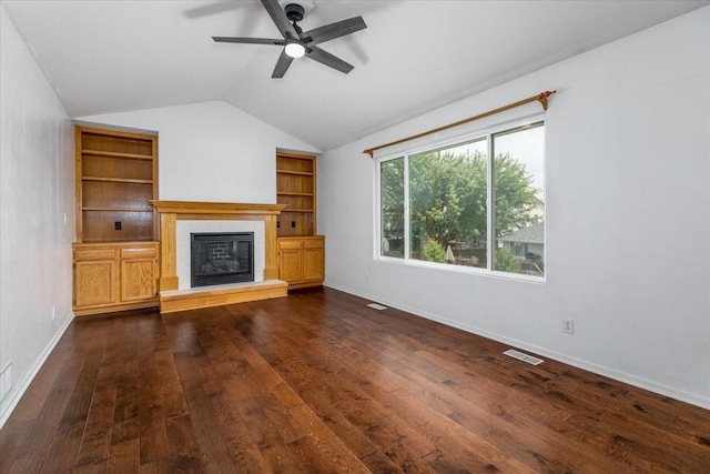 6825 Star View St, Des Moines, IA 50320 - unfurnished living room with ceiling fan, vaulted ceiling, a tiled fireplace, dark wood finished floors, and built in shelves