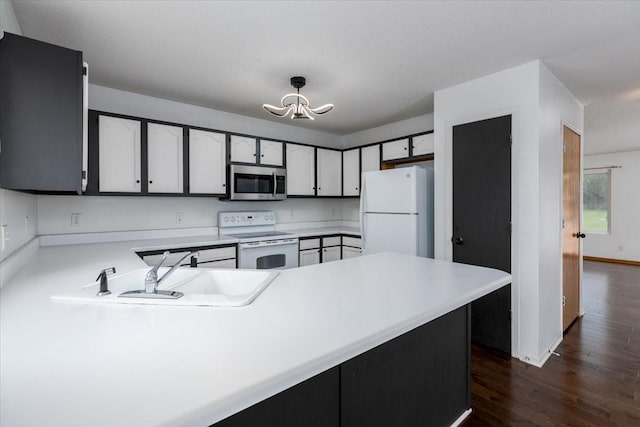 6825 Star View St, Des Moines, IA 50320 - kitchen with white appliances, dark wood-style floors, a chandelier, and light countertops