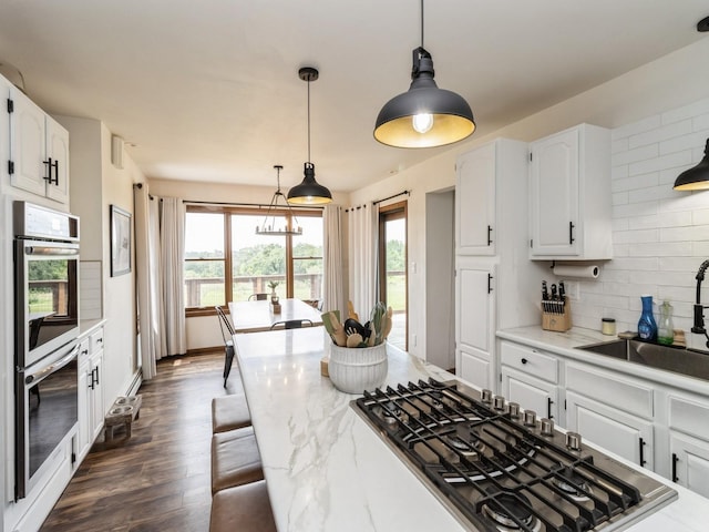 4791 Erbe St, Norwalk, IA 50211 - kitchen with appliances with stainless steel finishes, tasteful backsplash, healthy amount of natural light, and white cabinets