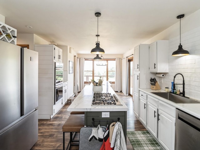 4791 Erbe St, Norwalk, IA 50211 - kitchen featuring stainless steel appliances, dark wood-style flooring, backsplash, white cabinetry, and hanging light fixtures