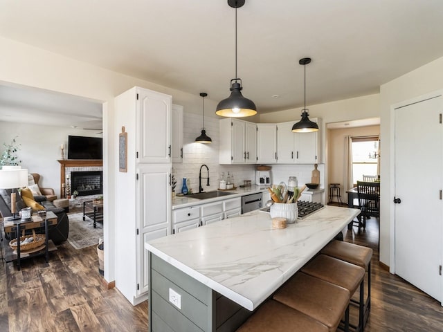 4791 Erbe St, Norwalk, IA 50211 - kitchen with cooktop, stainless steel dishwasher, tasteful backsplash, white cabinets, and dark wood-style floors