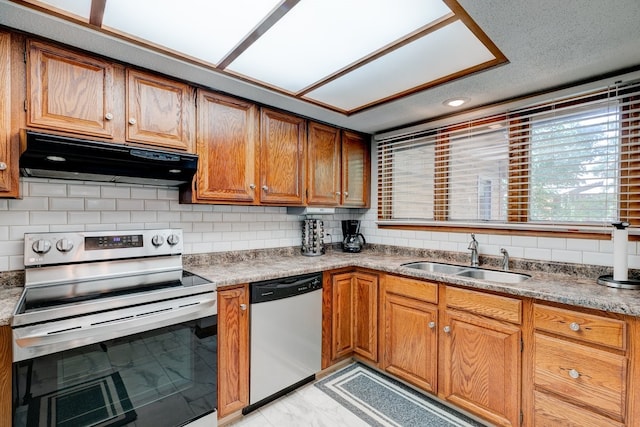 1116 42nd St, West Des Moines, IA 50266 - kitchen featuring appliances with stainless steel finishes, under cabinet range hood, backsplash, brown cabinets, and recessed lighting