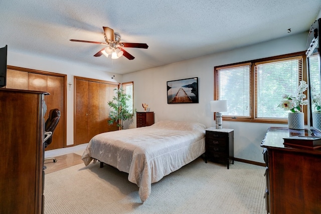 1116 42nd St, West Des Moines, IA 50266 - bedroom featuring light colored carpet, a textured ceiling, two closets, and ceiling fan