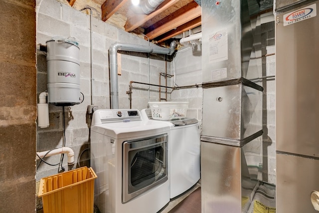 1116 42nd St, West Des Moines, IA 50266 - laundry room featuring washing machine and dryer, concrete block wall, and heating unit