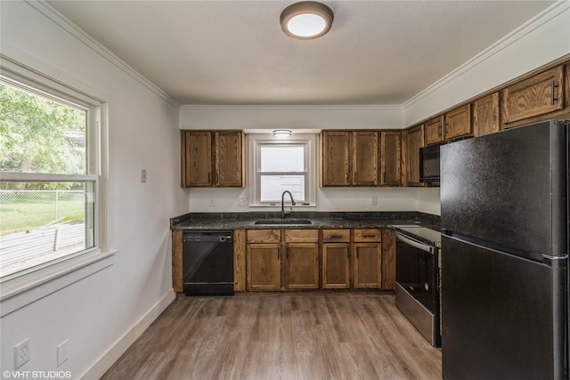 1212 Burnham Ave, Des Moines, IA 50315 - kitchen with black appliances, dark wood finished floors, healthy amount of natural light, and ornamental molding