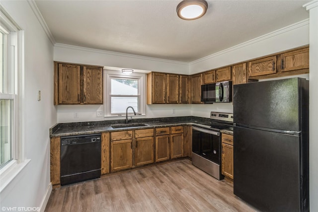 1212 Burnham Ave, Des Moines, IA 50315 - kitchen featuring black appliances, ornamental molding, light wood-style floors, and brown cabinets