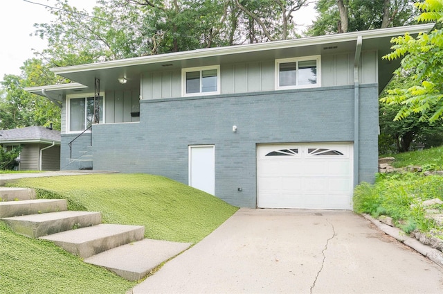2512 Boston Ave, Des Moines, IA 50310 - view of front facade featuring brick siding, an attached garage, driveway, and board and batten siding