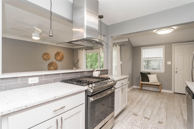 2512 Boston Ave, Des Moines, IA 50310 - kitchen featuring appliances with stainless steel finishes, island exhaust hood, backsplash, white cabinetry, and light stone counters