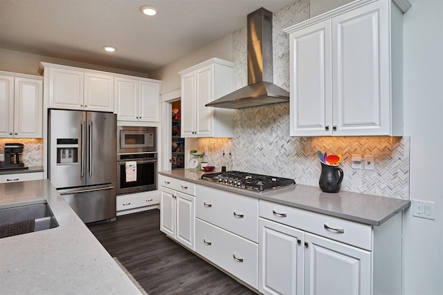 685 Indian Ridge Dr, Waukee, IA 50263 - kitchen with appliances with stainless steel finishes, wall chimney range hood, tasteful backsplash, white cabinetry, and recessed lighting