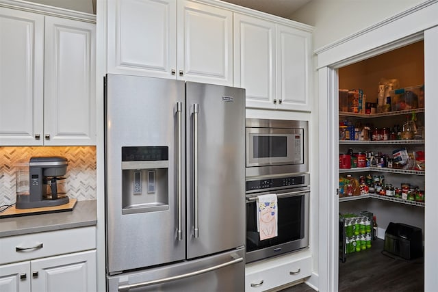 685 Indian Ridge Dr, Waukee, IA 50263 - kitchen featuring appliances with stainless steel finishes, white cabinetry, and decorative backsplash