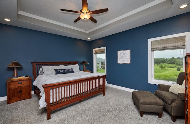 685 Indian Ridge Dr, Waukee, IA 50263 - carpeted bedroom with a tray ceiling, multiple windows, a textured ceiling, and ceiling fan