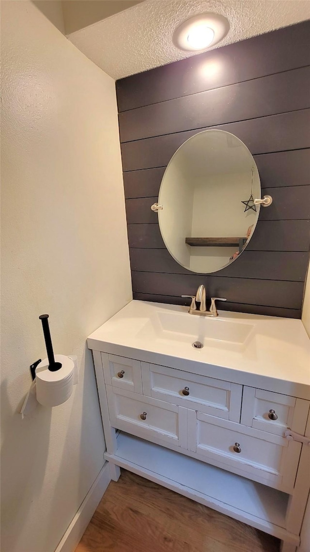 623 E 18th St N, Newton, IA 50208 - bathroom featuring vanity, wood finished floors, a textured ceiling, and wooden walls