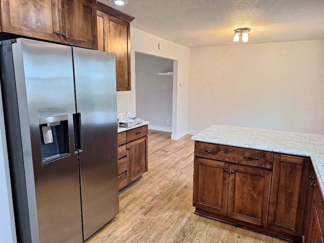 623 E 18th St N, Newton, IA 50208 - kitchen featuring stainless steel fridge with ice dispenser, light wood-style floors, and a textured ceiling