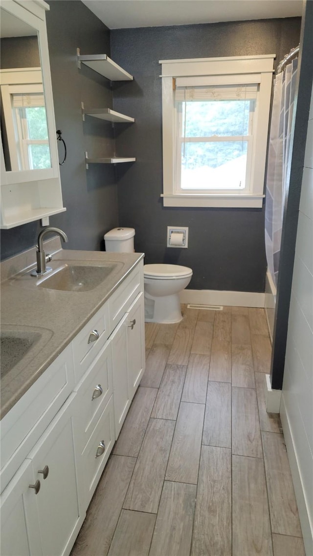 623 E 18th St N, Newton, IA 50208 - bathroom featuring wood tiled floors, double vanity, and shower / bath combo