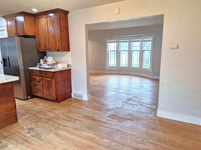 623 E 18th St N, Newton, IA 50208 - kitchen featuring light wood-style flooring, stainless steel fridge, and brown cabinets