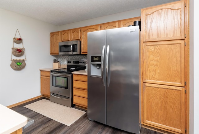14449 Briarwood Ln, Urbandale, IA 50323 - kitchen with stainless steel appliances, dark wood-style flooring, backsplash, light countertops, and a textured ceiling