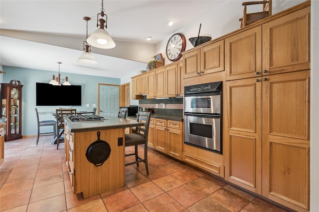 7 Hobart Pl, Grinnell, IA 50112 - kitchen featuring stainless steel appliances, dark countertops, a kitchen island, and a breakfast bar
