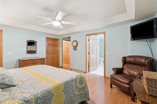 7 Hobart Pl, Grinnell, IA 50112 - bedroom with light wood-type flooring, a raised ceiling, ceiling fan, and connected bathroom