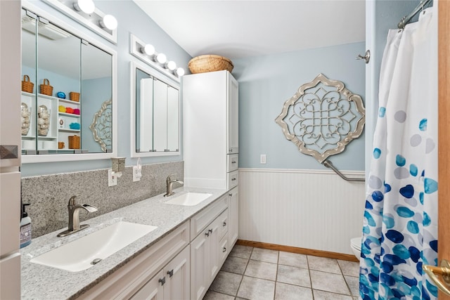 7 Hobart Pl, Grinnell, IA 50112 - full bathroom featuring double vanity, a wainscoted wall, and tile patterned flooring