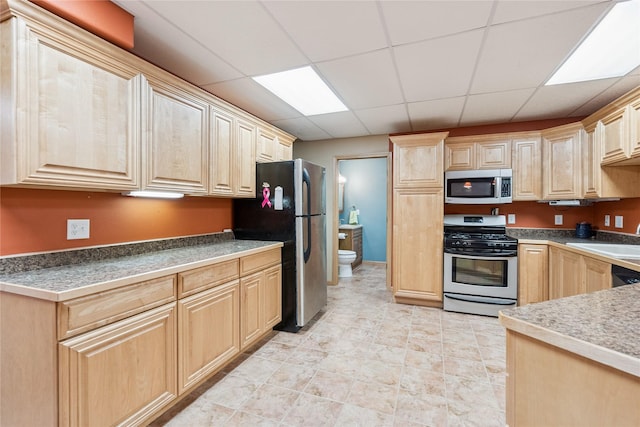7 Hobart Pl, Grinnell, IA 50112 - kitchen featuring appliances with stainless steel finishes, light brown cabinetry, and a drop ceiling