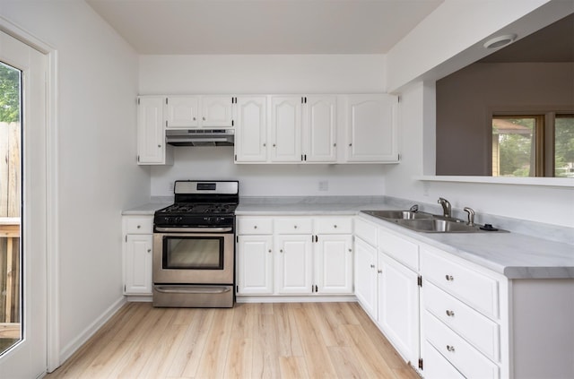 816 Boyd St, Des Moines, IA 50316 - kitchen with gas stove, under cabinet range hood, healthy amount of natural light, and light wood finished floors