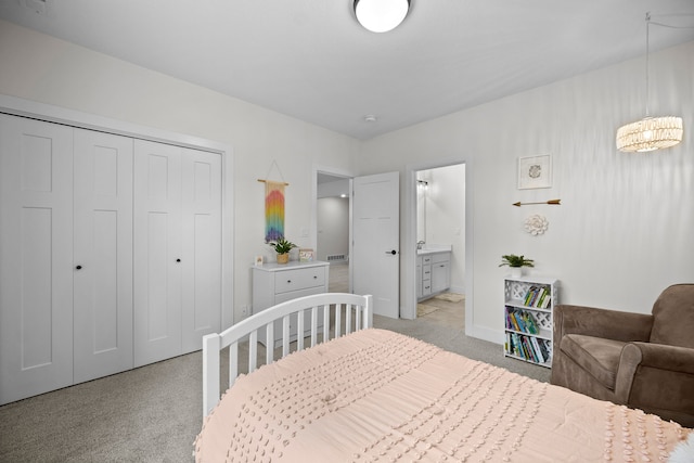 2309 NW 29th St, Ankeny, IA 50023 - bedroom with light colored carpet, a closet, a chandelier, and connected bathroom