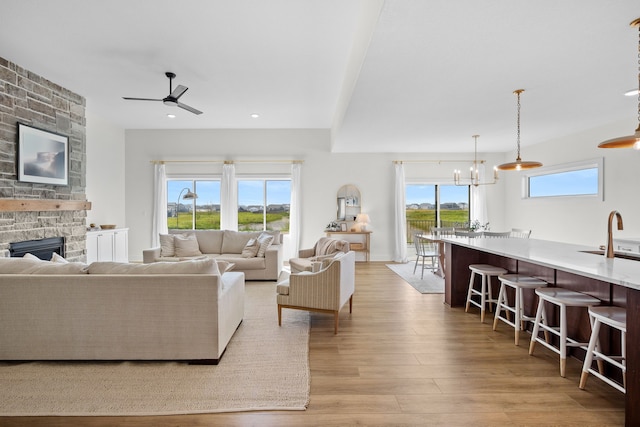 2309 NW 29th St, Ankeny, IA 50023 - living room featuring ceiling fan, light wood-style floors, a fireplace, a chandelier, and recessed lighting