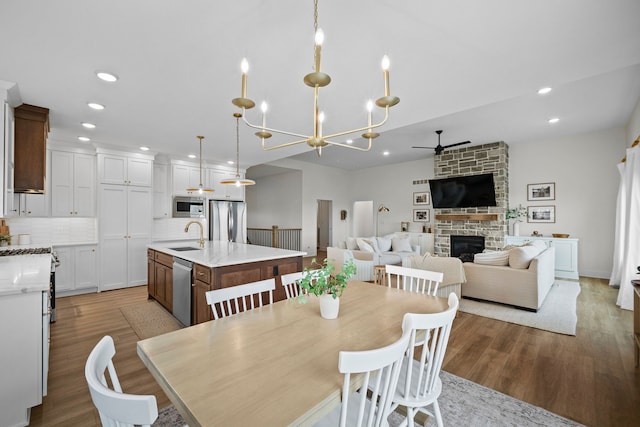 2309 NW 29th St, Ankeny, IA 50023 - dining room featuring ceiling fan, a stone fireplace, recessed lighting, and wood finished floors