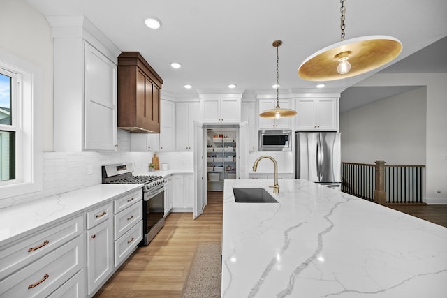 2309 NW 29th St, Ankeny, IA 50023 - kitchen featuring appliances with stainless steel finishes, recessed lighting, tasteful backsplash, light wood-style flooring, and white cabinetry