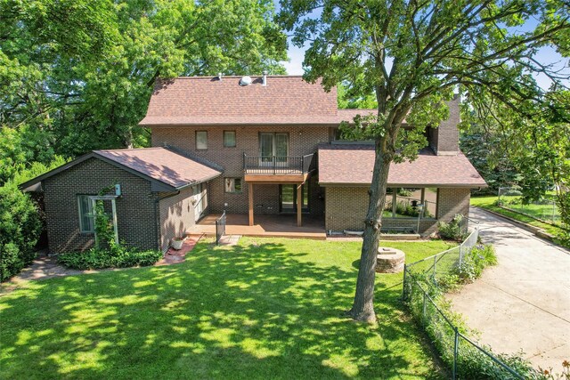 6542 Washington Ave, Windsor Heights, IA 50324 - rear view of property with brick siding, roof with shingles, a balcony, an attached garage, and driveway