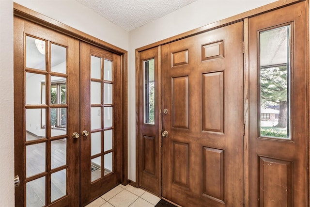 6542 Washington Ave, Windsor Heights, IA 50324 - foyer with french doors, light tile patterned floors, a textured ceiling, and healthy amount of natural light