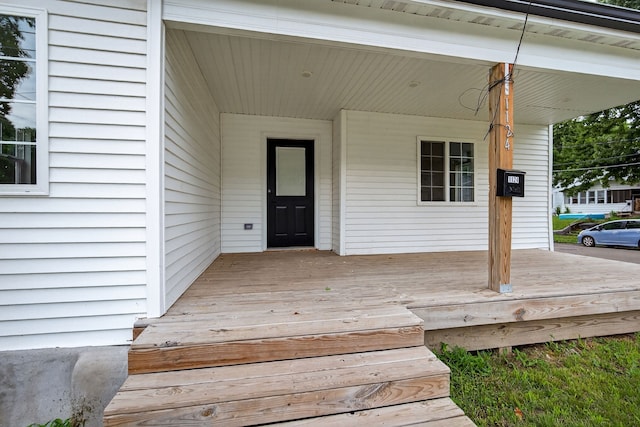 1124 13th St, Des Moines, IA 50314 - wooden porch featuring a carport
