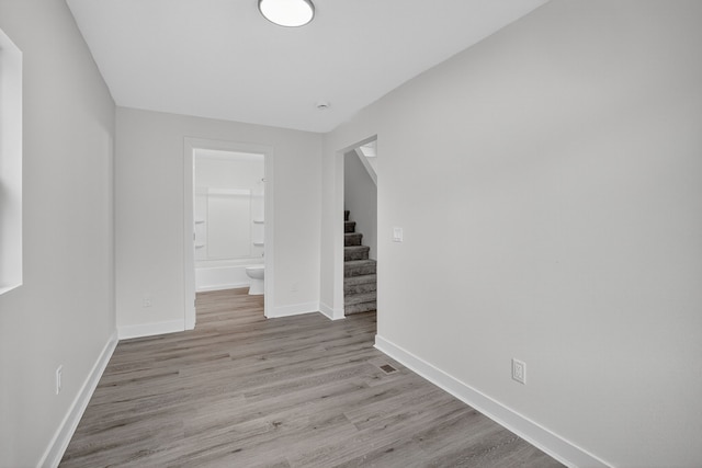1124 13th St, Des Moines, IA 50314 - spare room featuring wood finished floors and stairway