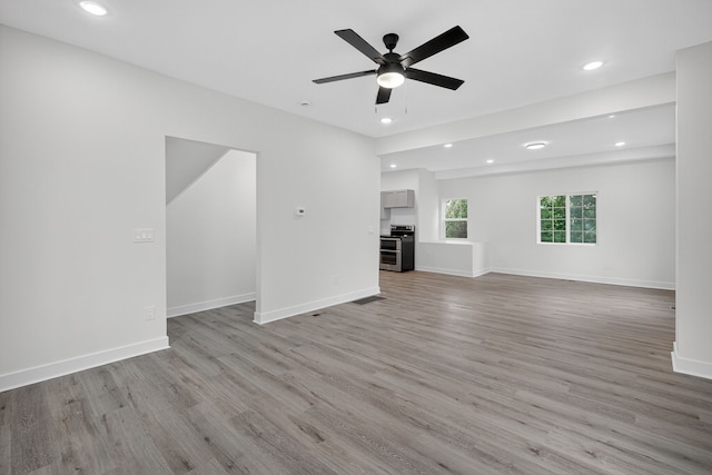 1124 13th St, Des Moines, IA 50314 - unfurnished living room with light wood-type flooring, a ceiling fan, and recessed lighting