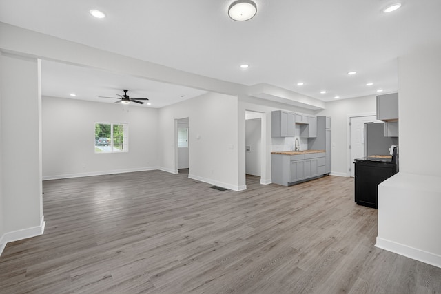 1124 13th St, Des Moines, IA 50314 - unfurnished living room featuring light wood-type flooring, recessed lighting, and a ceiling fan