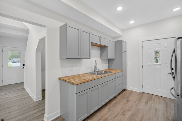 1124 13th St, Des Moines, IA 50314 - kitchen with gray cabinets, freestanding refrigerator, light wood-type flooring, butcher block counters, and recessed lighting