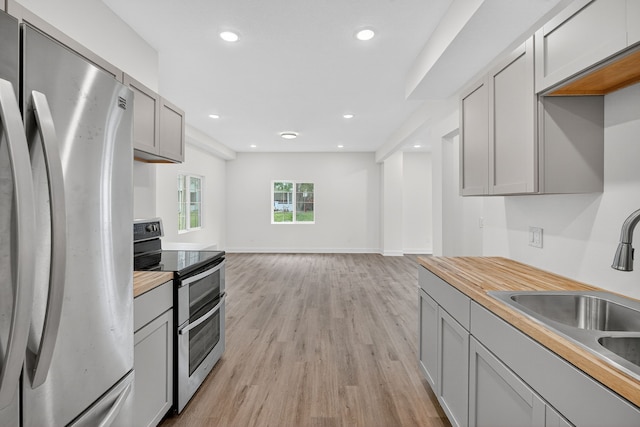 1124 13th St, Des Moines, IA 50314 - kitchen featuring appliances with stainless steel finishes, gray cabinets, light wood-style flooring, recessed lighting, and butcher block countertops