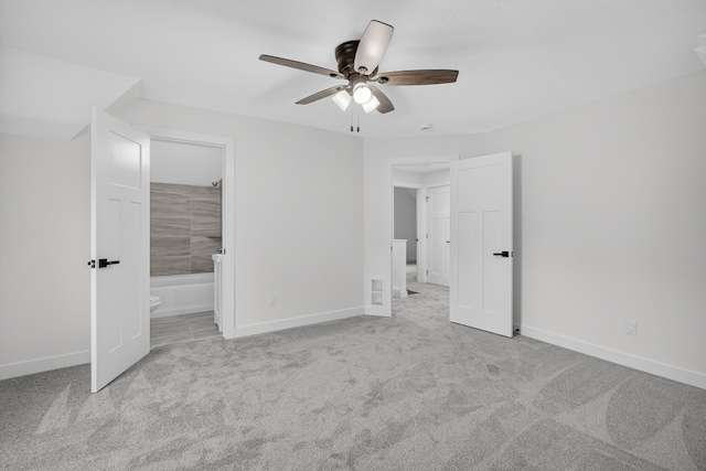 1124 13th St, Des Moines, IA 50314 - unfurnished bedroom featuring carpet, ensuite bathroom, and ceiling fan
