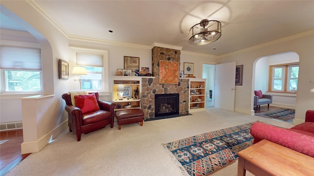 3827 Carpenter Ave, Des Moines, IA 50311 - living area featuring arched walkways, crown molding, a stone fireplace, and carpet